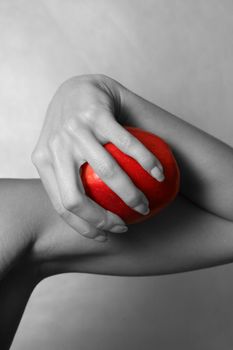 The girl holds in hands red an apple. Partial decolouration