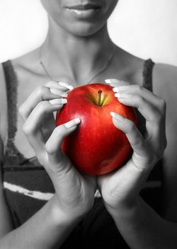 The girl holds in hands red an apple. Partial decolouration