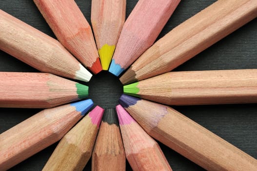 Colored pencils in star shape against black background