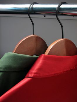 Stylish red and green shirts on wooden hangers. Christmas colors.