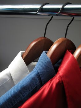 Colors of Russian flag: white, blue and red shirts on wooden hangers.