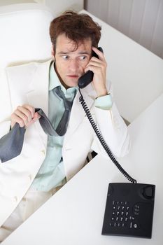 Young businessman talking on the phone very excited