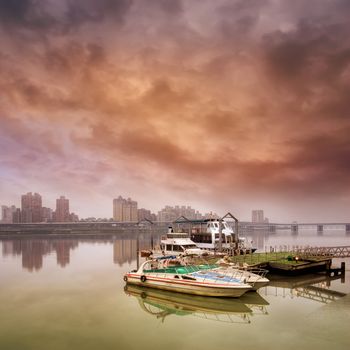 Dramatic landscape of boat on harbor against bad weather.