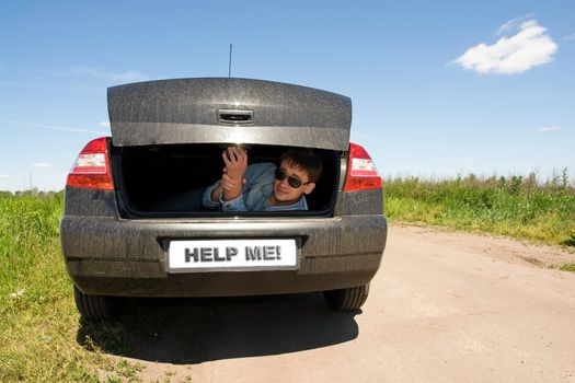 Help me! Man in the car luggage carrier.
