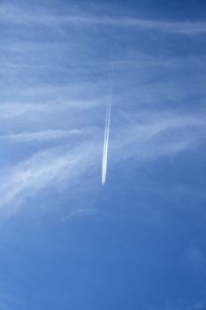 Trace of a jet airplane crossing the sky like a comet.