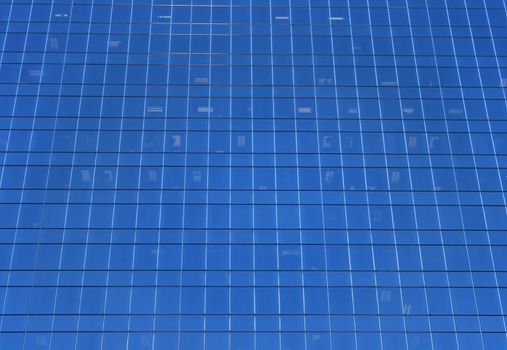 Glass-windowed wall of skyscraper. Blue windows background.
