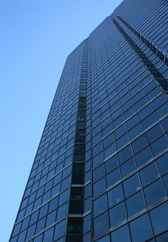 Perspective view of a blue glass-windowed skyscraper.