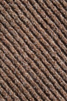 Diagonal lines of a brown striped fabric of a carpet.