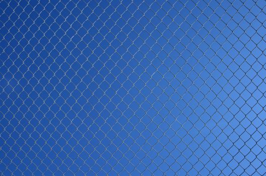 Chain link fence on a blue gradient sky background.