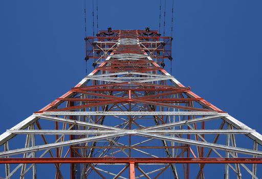 Red and white power tower, view from below.