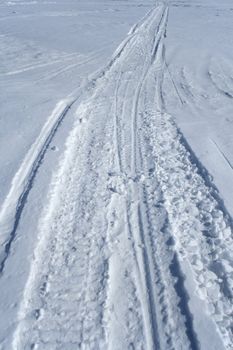 Skidoo track crossing the snowy winter terrain.