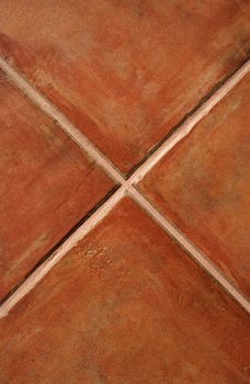 Closeup of terracotta ceramic tiles making a cross.