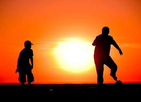 Kids having fun on the beach playing football