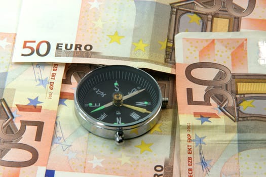 compass and fifty euro banknotes background business and finance concepts