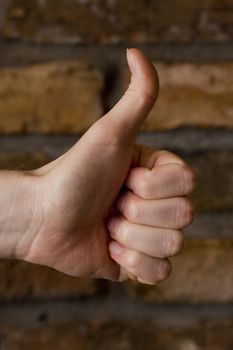 thumb up on brick wall background
