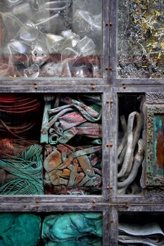 Background / abstract image of junk and trash stacked behind an urban window.
