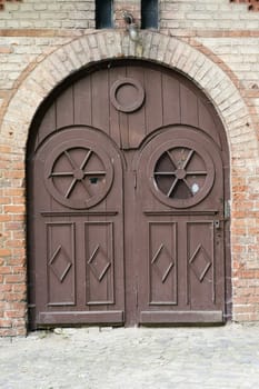 old brown wooden doors nd bricked wall