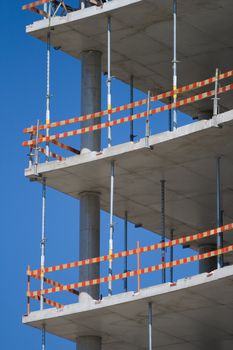 Part of unfinished building with caution marks and concrete walls