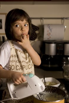 young girl having fun in the kitchen making cookies