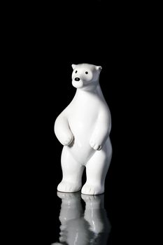 Ceramic polar bear on a black reflecting background.