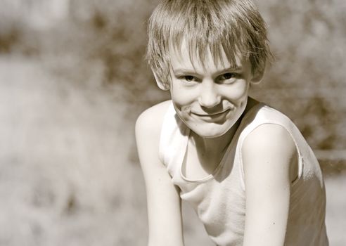 old photo of a boy in a singlet looking at the camera