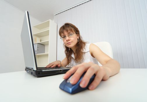 Young woman working with laptop photographed comic foreshortening