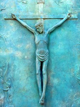 Christ on cross, vibrant blue due to copper oxidation