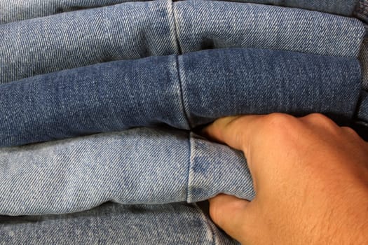 someone selecing a pair of blue jeans