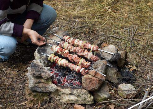preparing kebab at outdoors picnic using  natural stone fireplace