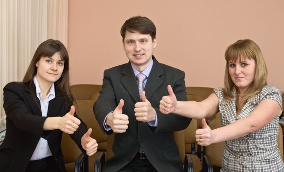 Team of cheerful businessmen show thumb up