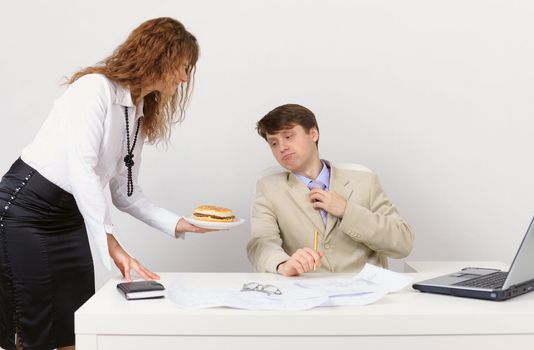 The secretary serves the Chief sandwich, in the workplace in the office