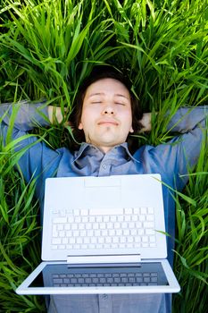 businessman rest on the grass with laptop