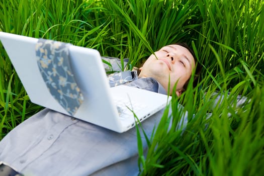 businessman rest on the grass with laptop