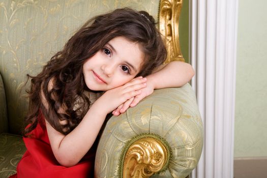 small girl with long hair in the armchair