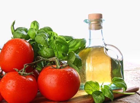 Tomatoes with fresh basil and bottle of olive oil