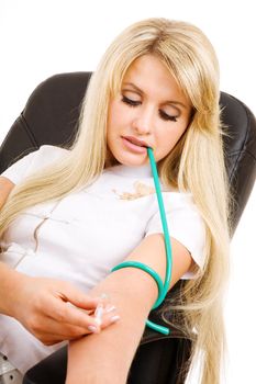 beautiful long haired blond girl with syringe making injection in vein