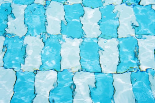 Background of blurred floor in pool with rippled white and blue rectangles.