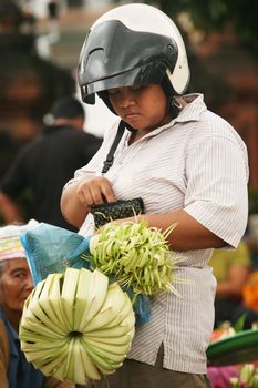 The Indonesian woman with a purse in the market