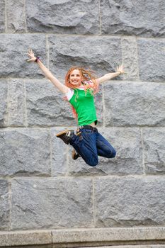 modern girl jumping near the wall