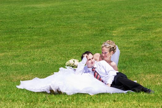 rest of newly married couple on the grass