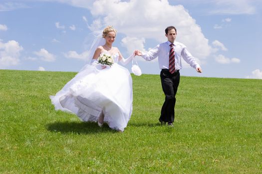 bride and groom walk in the park