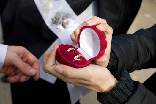 Man holds in hands a box with golden rings