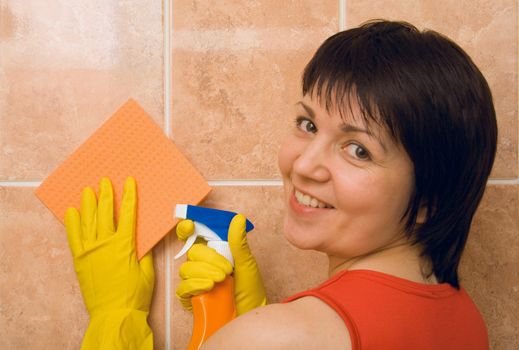 Young woman with a smile cleans a tile