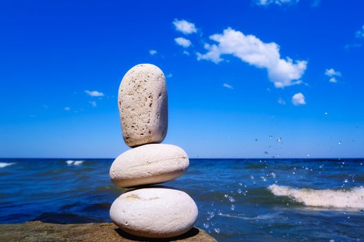 Three pebbles on the background of water drops of the sea