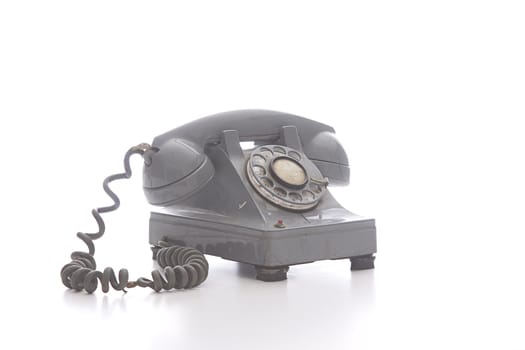 dirty vintage gray rotary phone with crack casing and expose wired