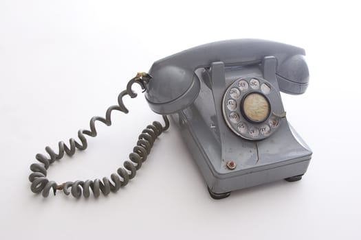 dirty vintage gray rotary phone with crack casing and expose wired