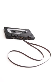 old tape cassette with cover sticker rip apart and part of the tape unrolled