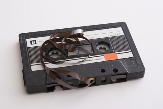 old tape cassette with cover sticker and part of the tape unrolled