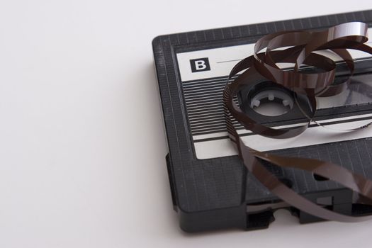 old tape cassette with cover sticker and part of the tape unrolled