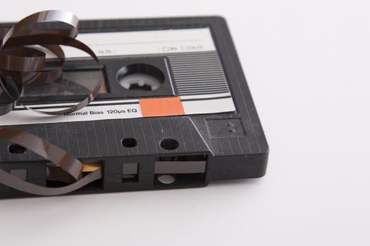 old tape cassette with cover sticker and part of the tape unrolled